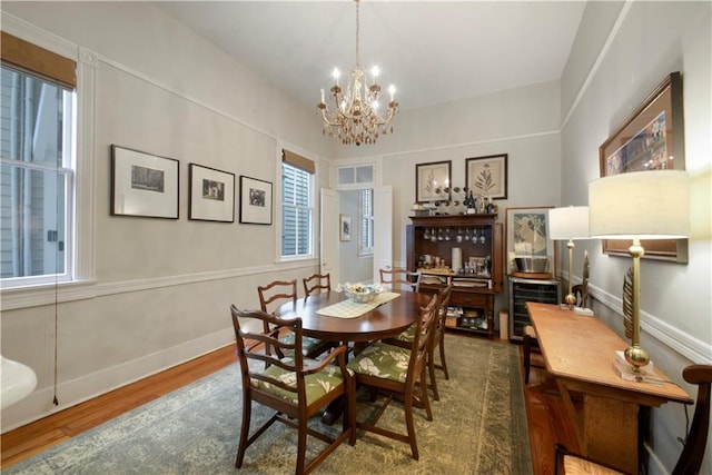 dining space featuring wood-type flooring and a notable chandelier