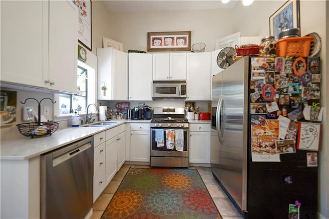 kitchen featuring light tile patterned floors, white cabinetry, sink, and appliances with stainless steel finishes