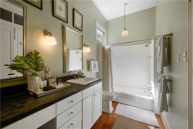 full bathroom featuring hardwood / wood-style floors, vanity, toilet, and shower / tub combo with curtain