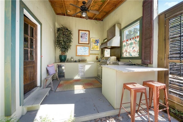 interior space with ceiling fan and beverage cooler