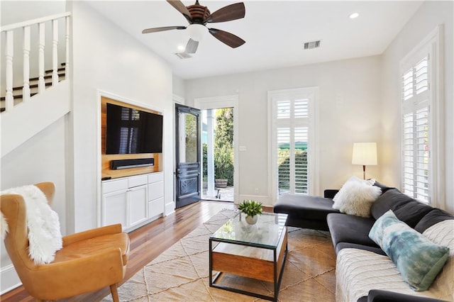 living room with light hardwood / wood-style floors, a wealth of natural light, and ceiling fan