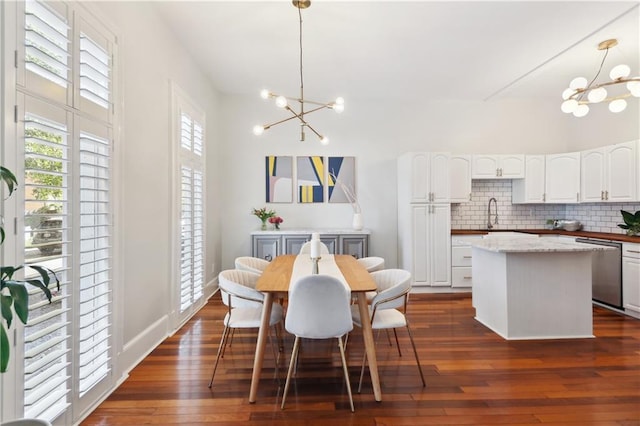 dining space featuring a chandelier, sink, and dark wood-type flooring