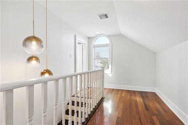 hallway with dark wood-type flooring and lofted ceiling