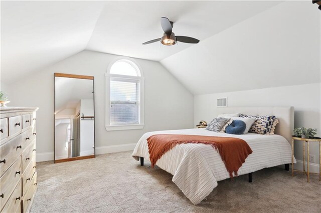 bedroom with ceiling fan, lofted ceiling, and light carpet