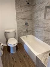 bathroom with hardwood / wood-style flooring and toilet