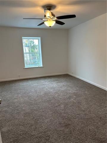 carpeted spare room with ceiling fan