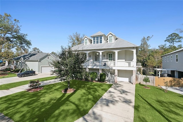 view of front of house featuring a garage, a front lawn, and covered porch