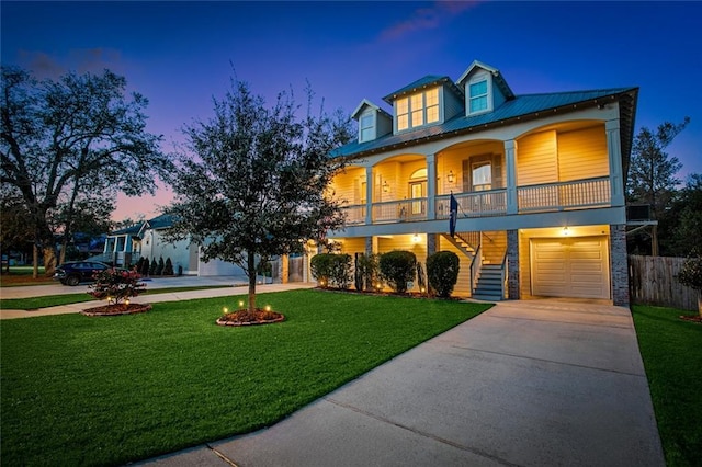 view of front of property with a porch, a garage, and a yard