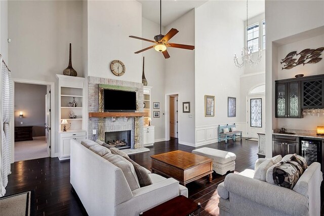 foyer entrance with dark wood-type flooring, french doors, a notable chandelier, a towering ceiling, and beverage cooler