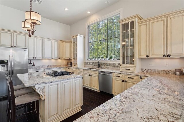 kitchen with a kitchen island, light stone counters, and an inviting chandelier