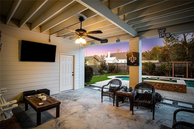 patio terrace at dusk featuring outdoor lounge area, ceiling fan, and a pool with hot tub