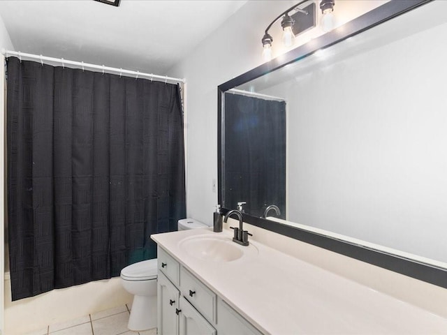 bathroom with toilet, vanity, and tile patterned floors