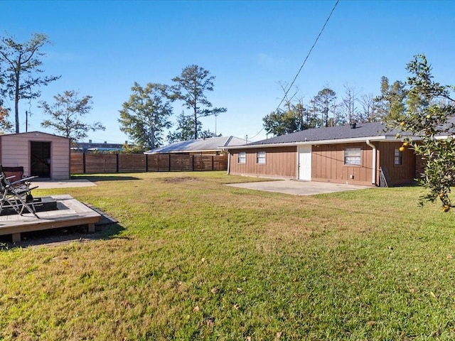 view of yard with a storage unit, a patio, and a wooden deck