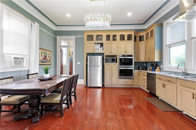 kitchen featuring light stone countertops, appliances with stainless steel finishes, crown molding, dark wood-type flooring, and hanging light fixtures