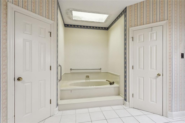 bathroom with tile patterned flooring, a skylight, and a tub