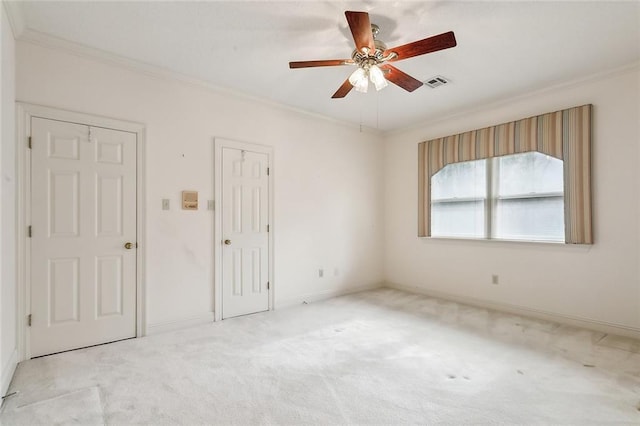 carpeted empty room featuring ceiling fan and ornamental molding