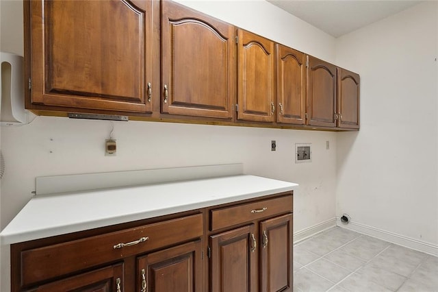 laundry room with washer hookup, electric dryer hookup, cabinets, and light tile patterned floors