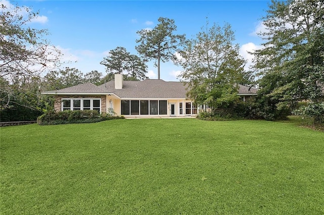 back of property featuring a sunroom and a yard