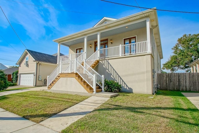 view of front of home featuring a porch, a garage, and a front lawn