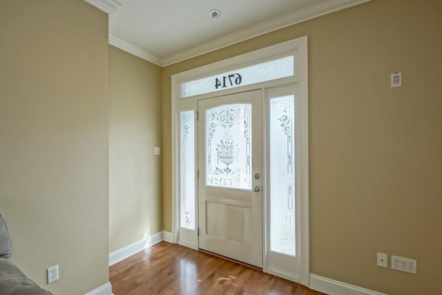 entrance foyer with light hardwood / wood-style floors and crown molding