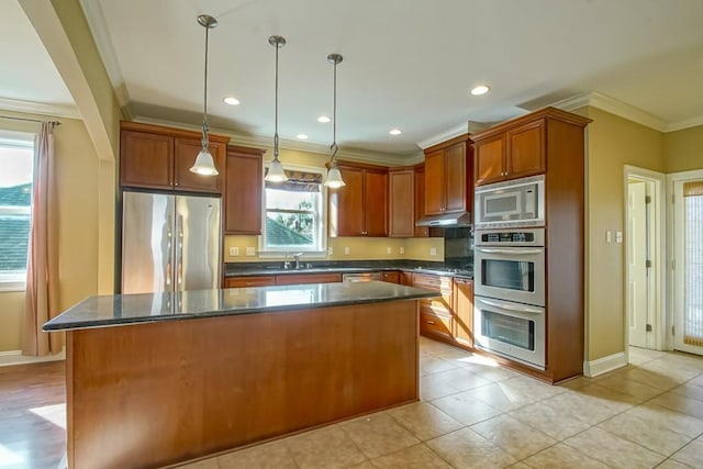 kitchen featuring appliances with stainless steel finishes, ornamental molding, a center island, hanging light fixtures, and light tile patterned flooring