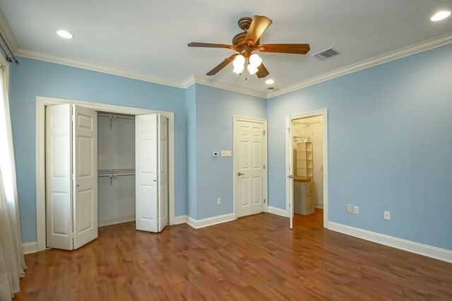 unfurnished bedroom featuring hardwood / wood-style flooring, ceiling fan, and crown molding