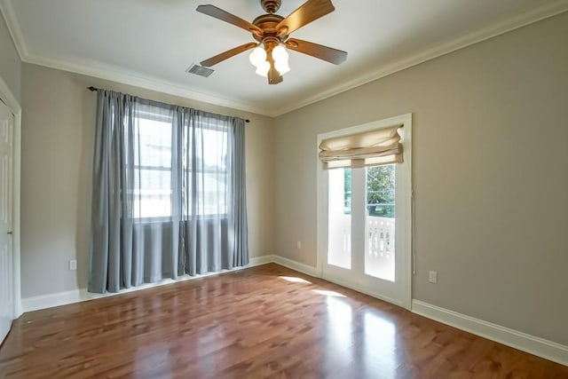 empty room with ornamental molding, hardwood / wood-style flooring, and a healthy amount of sunlight