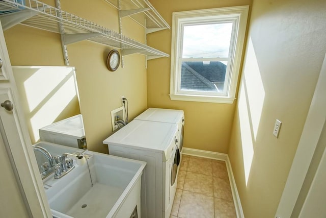 laundry room with sink, light tile patterned floors, and washer and dryer