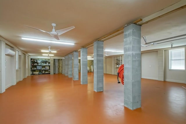 basement featuring an AC wall unit and ceiling fan