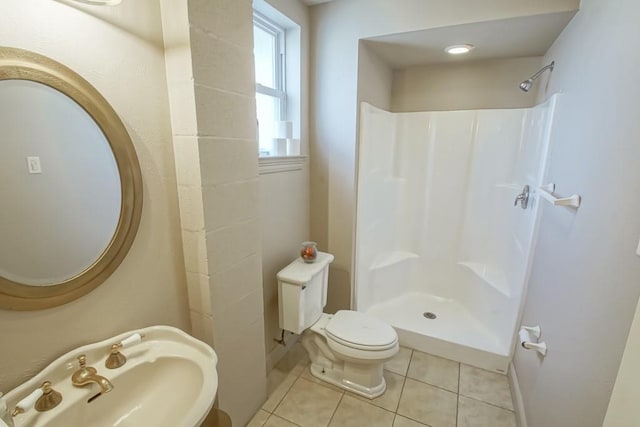 bathroom featuring tile patterned floors, sink, walk in shower, and toilet