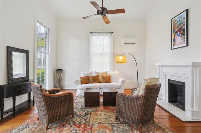 living room featuring an AC wall unit, a healthy amount of sunlight, and hardwood / wood-style flooring