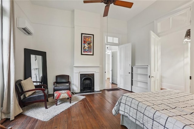 bedroom with dark hardwood / wood-style floors, ceiling fan, and an AC wall unit