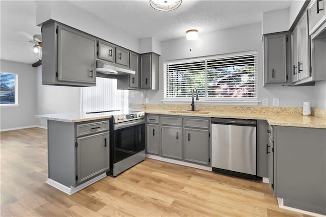 kitchen featuring gray cabinets, sink, appliances with stainless steel finishes, and light hardwood / wood-style flooring