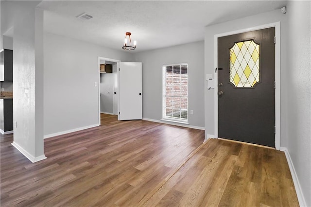 foyer entrance featuring wood-type flooring and a notable chandelier