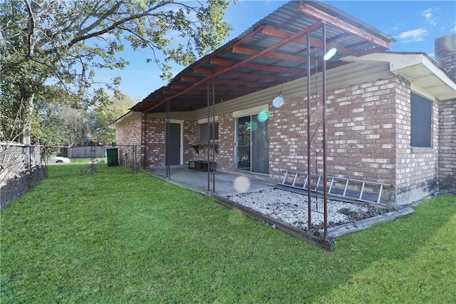 rear view of house with a patio and a lawn