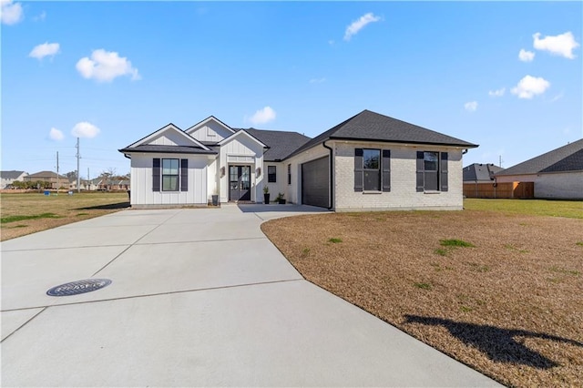 modern inspired farmhouse featuring a garage and a front lawn