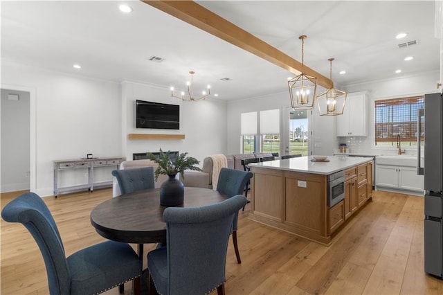 kitchen featuring white cabinets, a center island, decorative backsplash, hanging light fixtures, and stainless steel fridge