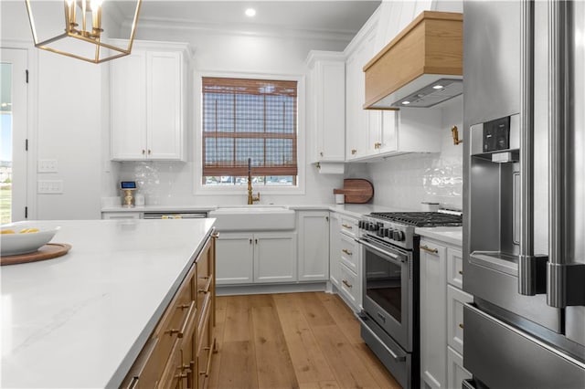 kitchen with sink, white cabinetry, appliances with stainless steel finishes, and pendant lighting