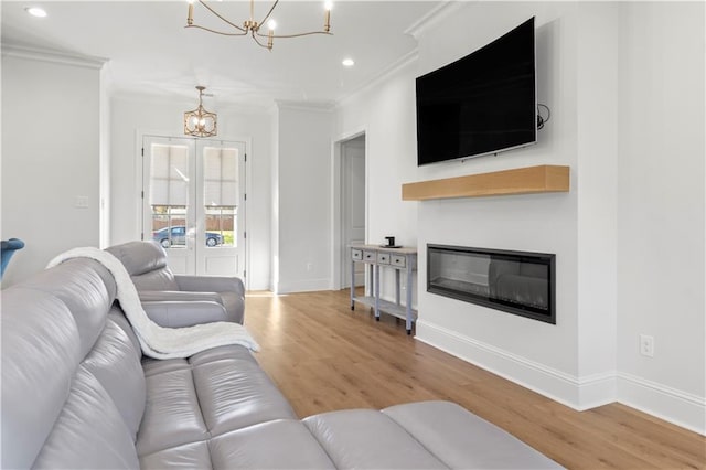 living room featuring an inviting chandelier, light hardwood / wood-style flooring, and ornamental molding