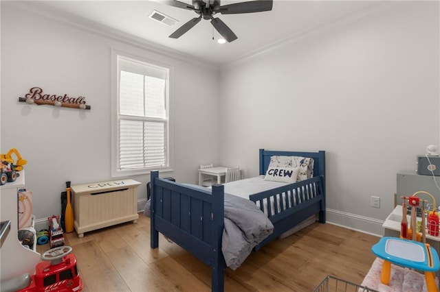 bedroom featuring light hardwood / wood-style floors, ceiling fan, and ornamental molding