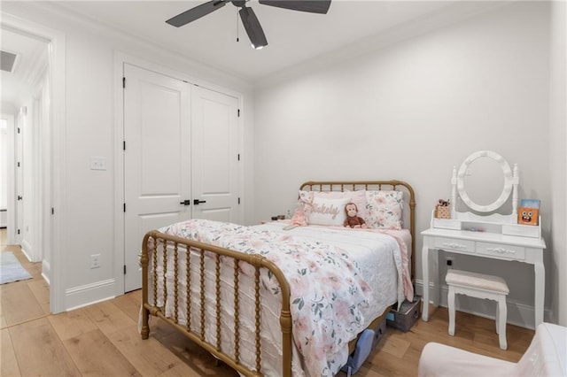 bedroom featuring light hardwood / wood-style floors, a closet, ceiling fan, and ornamental molding