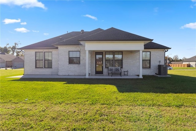 rear view of property with a patio area, a yard, and central AC unit