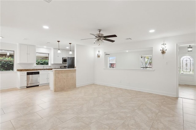 kitchen with white cabinetry, a center island, ceiling fan, hanging light fixtures, and stainless steel appliances