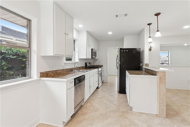 kitchen with kitchen peninsula, stainless steel appliances, sink, white cabinetry, and hanging light fixtures