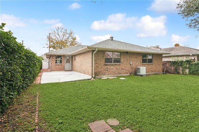 rear view of property featuring a lawn, cooling unit, and a patio