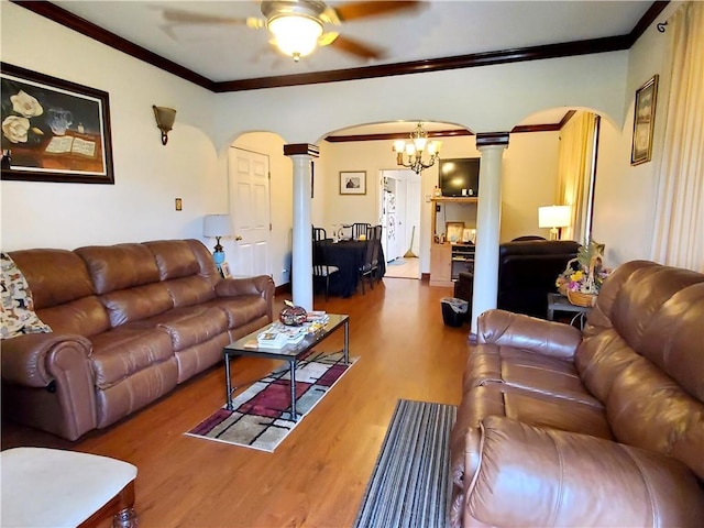 living room with hardwood / wood-style floors, ceiling fan with notable chandelier, ornate columns, and ornamental molding