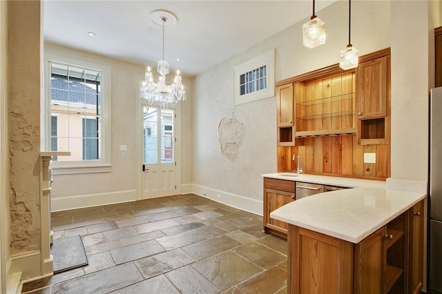 kitchen featuring sink, dishwasher, hanging light fixtures, a notable chandelier, and kitchen peninsula