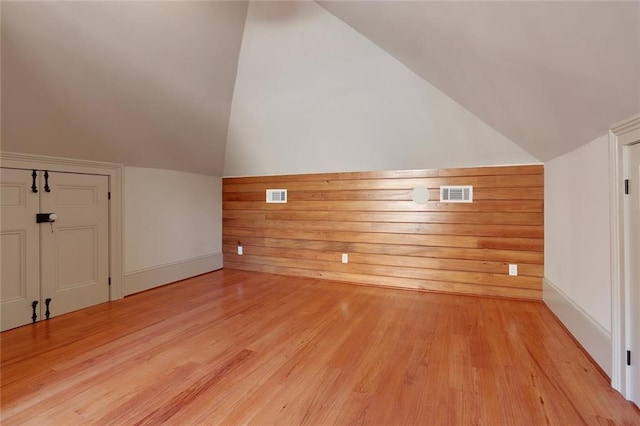 additional living space featuring light hardwood / wood-style flooring and vaulted ceiling