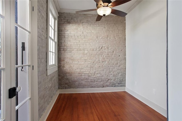 spare room featuring wood-type flooring, ceiling fan, and ornamental molding