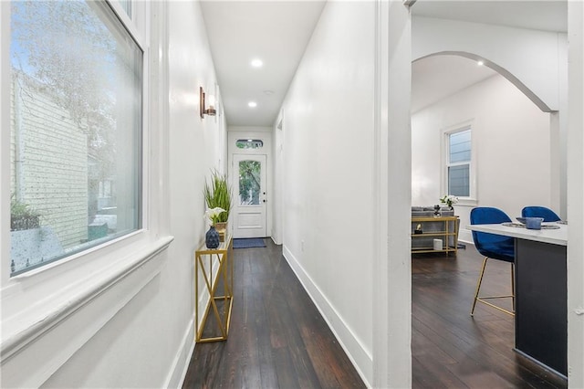 2417 Royal St, New Orleans, LA 70117 - hallway featuring arched walkways, dark wood-style flooring, recessed lighting, and plenty of natural light